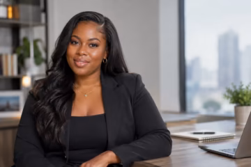 Shannon Tanisha Byles in a professional portrait at a modern office workspace.