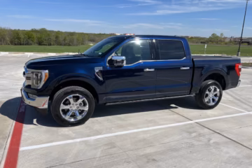 Ford pickup truck in deep Antimatter Blue paint, parked outdoors with a scenic countryside backdrop.